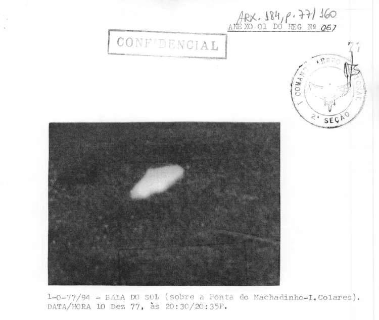 Folha carimbada como confidencial com fotografia noturna de uma mancha luminosa alongada sobre fundo escuro, legendada Baía do Sol, 10 de dezembro de 1977